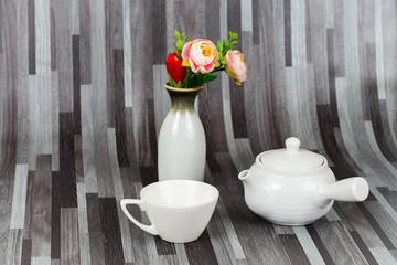 white tea pot and cup on wood