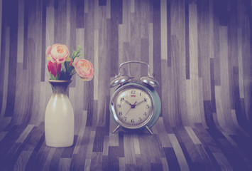 alarm clock  and rose flower in vase