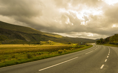 Fototapeta premium Landscape road in mountains under cloudy sky