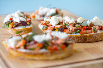Bruschetta with tomato, cheese and olive oil on a blue background