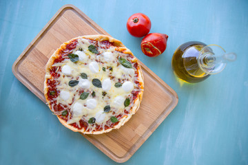 pizza with olive oil and tomatoes on a blue background, Top view
