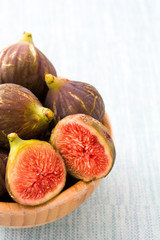 Fresh figs in bowl on blue background
