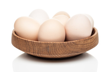 chicken eggs in a wooden plate isolated on white background