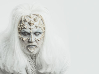 man with beard and thorns on face has makeup