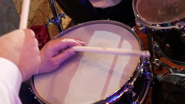 hand of the musician beat on the edge of the snare drum on jazz band performing on stage. Slow motion close-up