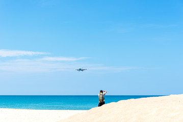 Photographer take a photo beautiful beach during airplane at Phuket airport, Thailand