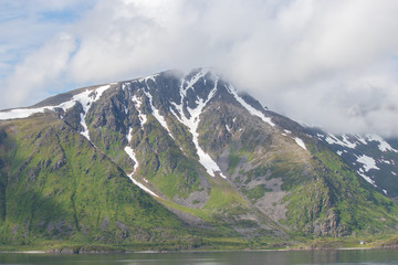 Fototapeta na wymiar Mountain in clouds on Soroya island in Finnmark county in northern Norway.