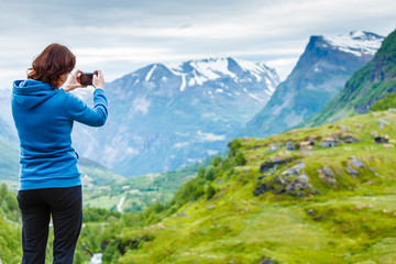 Fototapeta na wymiar Tourist taking photo in mountains Norway