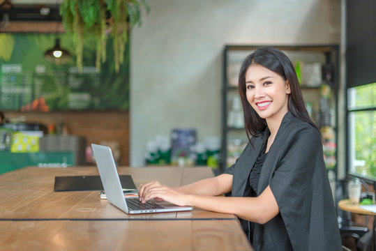 Beautiful  business woman while sitting at her desk in office typing on her laptop computer.