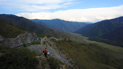 Aerial. mother with children on top of the mountain. family enjoying a beautiful view. Altai, Siberia. Aerial camera shot