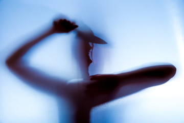 hinter einem Vorhang ist der Schatten einer Frau zu sehen, sie hält ein Messer in der Hand