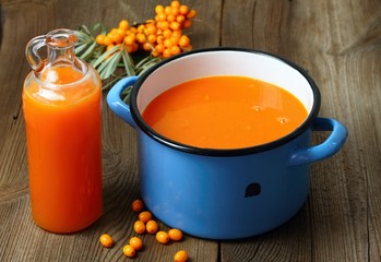 Homemade sea buckthorn liqueur, Hippophae rhamnoides, wood table