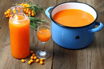 Homemade sea buckthorn liqueur, Hippophae rhamnoides, wood table