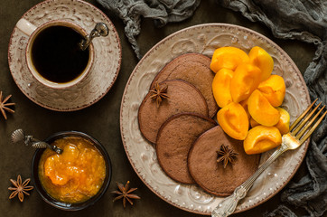 Fototapeta premium Chocolate pancakes with apricot jam and coffee