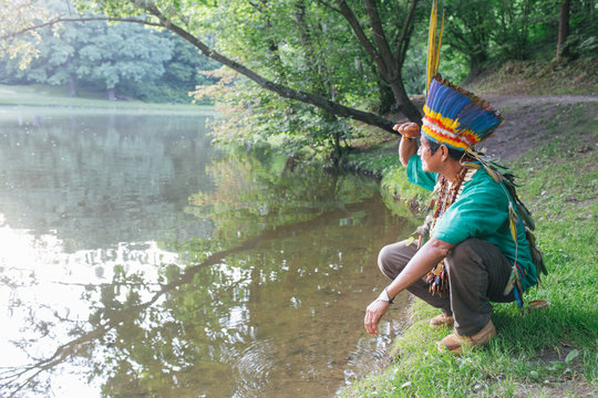 Concentrated ethnic priest on lakeside