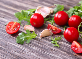 Fresh tomatoes with salad leaves on the table. Background.
