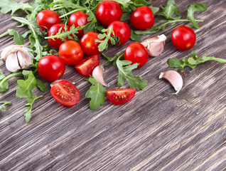 Fresh tomatoes with salad leaves on the table. Background.