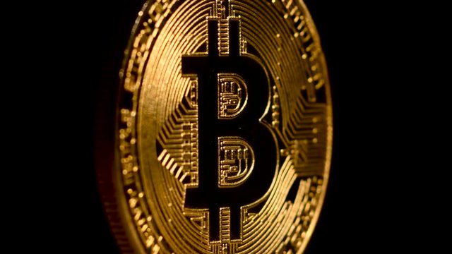 Gold Bitcoin rotates on a black background