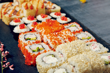 Menu of Japanese sushi rolls on black background