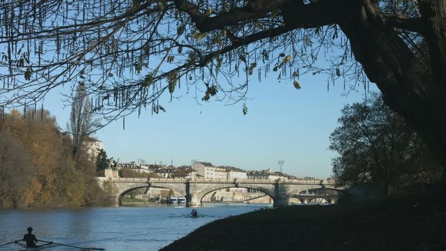 Turin in autumn along the Po river with rowers training and historical bridge