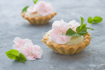 Mini tarts close up. Homemade dessert with delicious catalonian traditional cream and fresh flowers