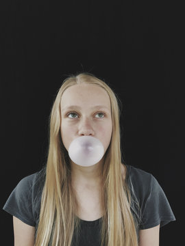 Teenage girl blowing bubble gum bubble