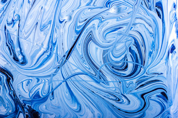 Abstract background. Paints. Fantastic patterns obtained by mixing blue paint white