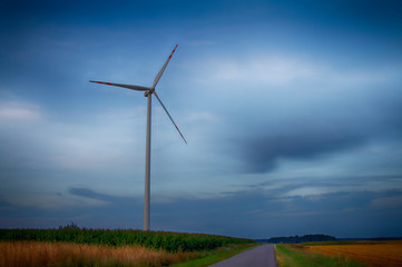 Obraz premium Windmills, power stations, cloudy skies and fields
