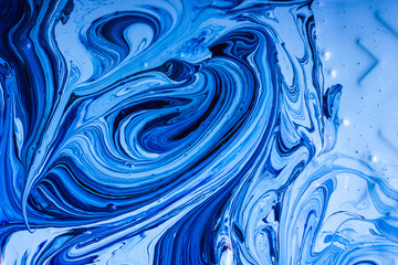 Abstract background. Paints. Fantastic patterns obtained by mixing blue paint white