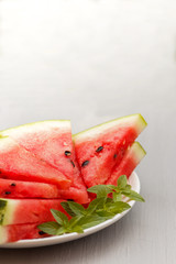 Slices of watermelon on a plate on a gray background. Selective focus Copy space