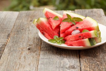 Slices of watermelon on a plate on a wooden background. Selective focus Copy space