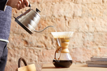 Someone filling up chemex carafe.