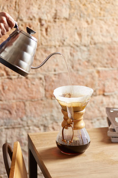 Someone filling up a chemex carafe.