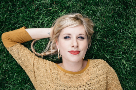 Young blond woman lying in grass