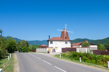 a house with a mill on a mountain road