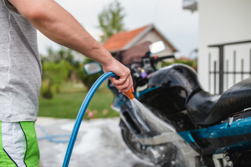 A man cleaning motorcycle - motorcycle detailing (or valeting) concept. Selective focus. 