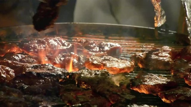 Schwenkgrill Grillen Grill mit Flammen Steaks und Schwenkern auf Holzkohle