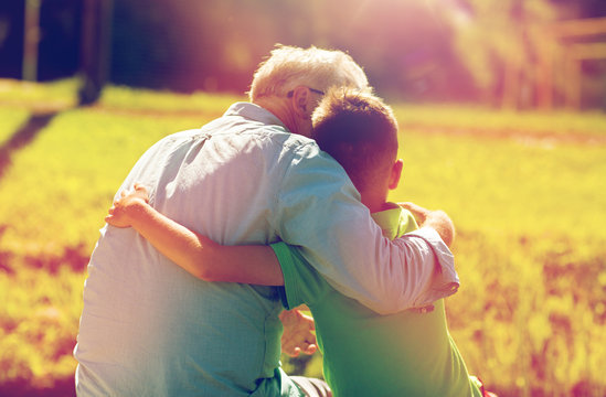 Grandfather And Grandson Hugging Outdoors