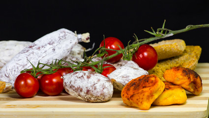delicious chopping board of cured meat, bakery product and pachino's tomatoes
