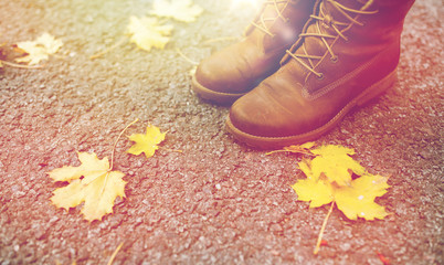 female feet in boots and autumn leaves