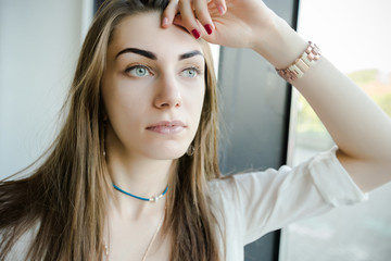 Naklejka premium Portrait of trendy young caucasian woman posing near a window.