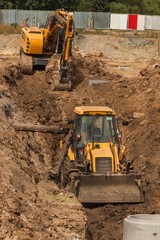Obraz premium Construction of a new sewerage system. The bulldozer digs a trench for sewer pipes. Construction works.