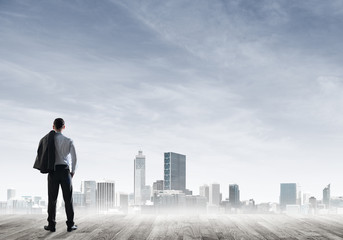 Motivation and inspiration concept with modern cityscape and businessman observing it