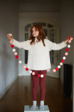 Little girl with christmas ornaments decorating home