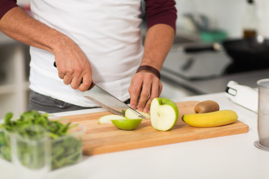 man chopping fruits and cooking at home kitchen