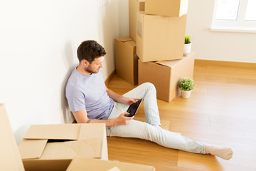 man with tablet pc and boxes moving to new home