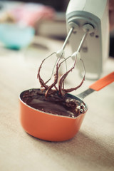 Woman hands mixing melted chocolate in the kitchen