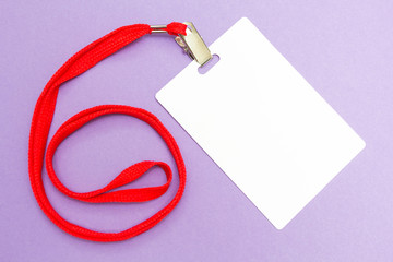 Blank badge mockup isolated on purple. Plain empty name tag mock up with red string.