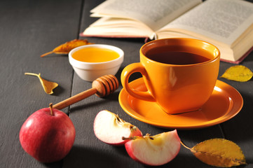 Autumn still life cup of tea, honey and book on the table