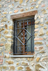 window with iron grating on stone wall - 169045151